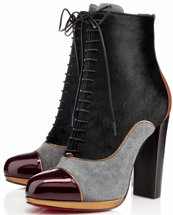The Christian Louboutin “Pate A Chou” ankle boots showcase a striking mixed-media construction, combining soft gray suede, smooth black leather, and pony-hair panels for rich textural contrast