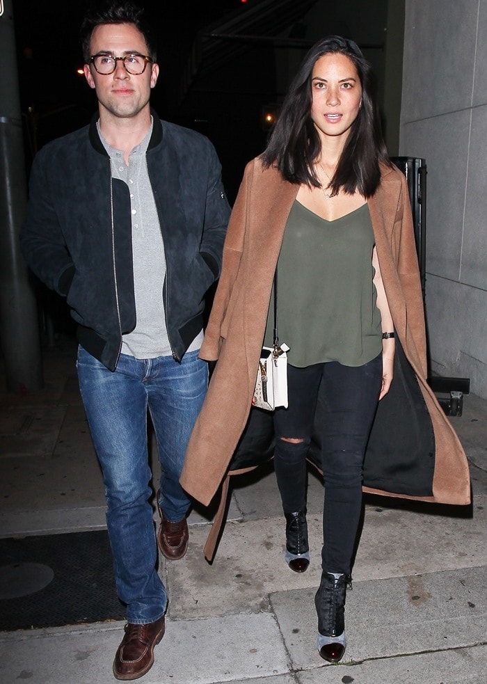 Olivia Munn steps out in Los Angeles wearing a camel coat over a fluid olive camisole and ripped black jeans, finished with mixed-texture Christian Louboutin ankle boots