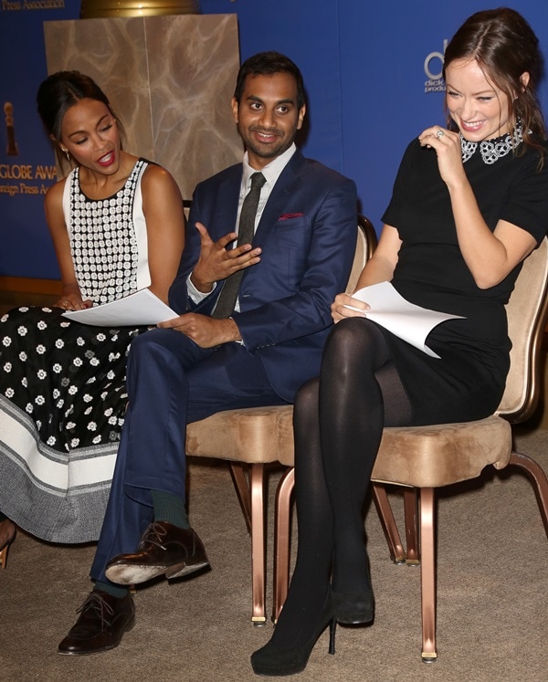 Zoe Saldaña sports a striking black and white patterned ensemble, while Aziz Ansari is sharply dressed in a blue suit, and Olivia Wilde adds sophistication with a black dress featuring an embellished collar and chic platform heels