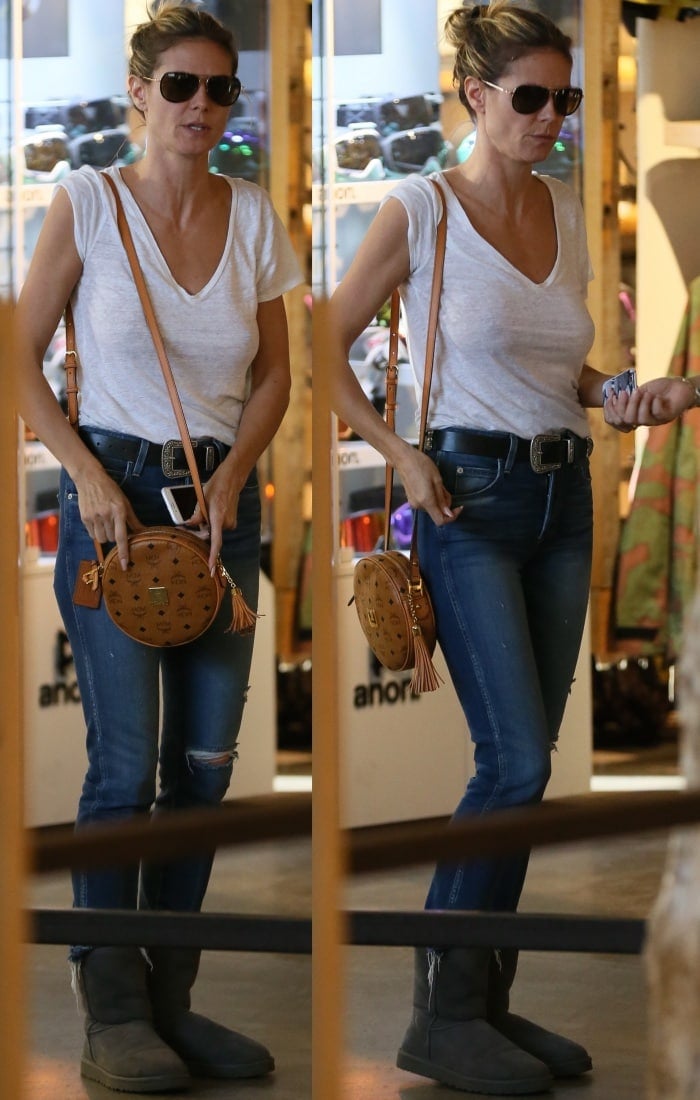 Heidi Klum was spotted shopping in Beverly Hills, California, on November 23, 2016, rocking casual chic style with grey UGG Classic Short boots, Amo Babe high-rise crop jeans, a simple white tee, and a stylish MCM Heritage Tambourine shoulder bag