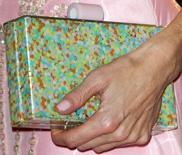 Laura Bailey complements her look with a multicolored polka dot clutch and a soft, neutral manicure, adding a playful yet elegant touch to her ensemble