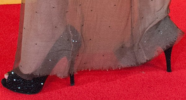 Amy Willerton pairs her sheer embellished gown with towering black sequin peep-toe pumps that add height and drama to her red carpet look