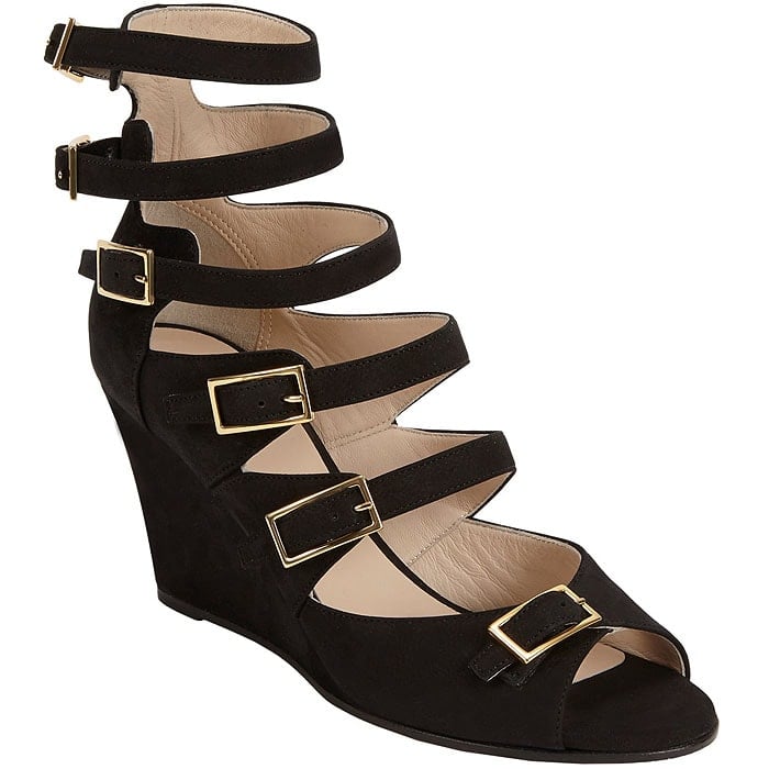 Chloé “Arce” multi-buckled black leather wedge sandals feature a sculptural high wedge and bold gold-tone hardware, combining gladiator-inspired straps with a modern, architectural silhouette