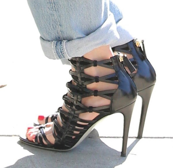 Jessie J's strappy caged heels perfectly highlight her chic red pedicure, adding a polished and edgy finish to her rolled-up boyfriend jeans