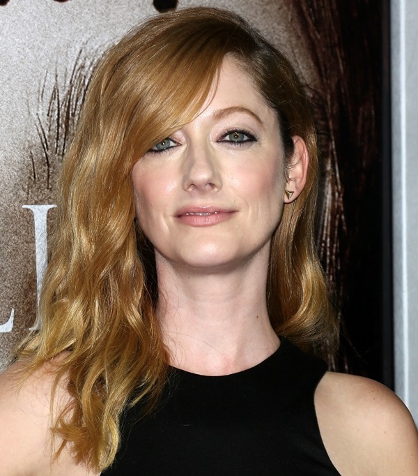 Judy Greer wears her hair in soft, side-swept waves with a deep side part, creating a glamorous yet effortless red carpet look