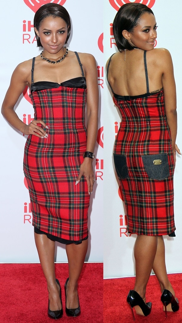 Kat Graham paired glossy black Casadei “Blade” pumps with a curve-hugging red plaid Dolce Gabbana dress