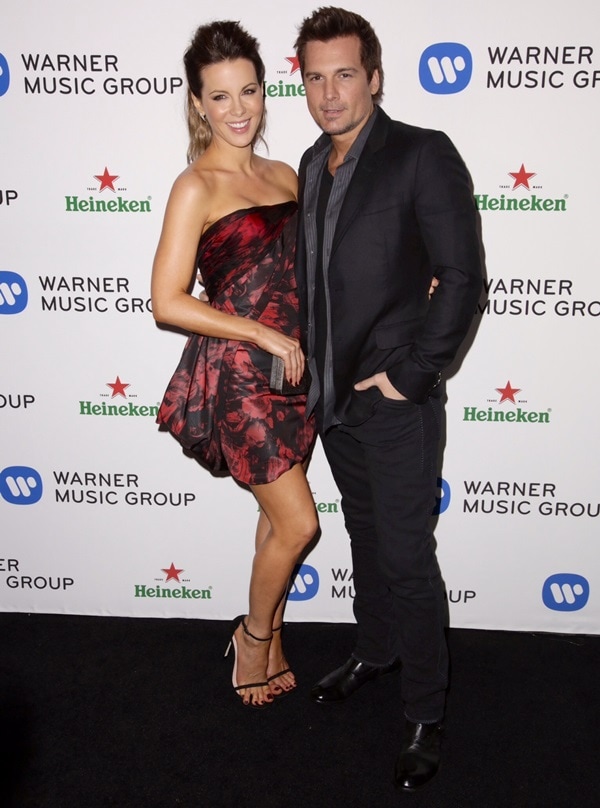 Kate Beckinsale stuns in a strapless red and black floral mini dress, paired with strappy black sandals, while posing with Len Wiseman at the Warner Music Group's Grammy celebration