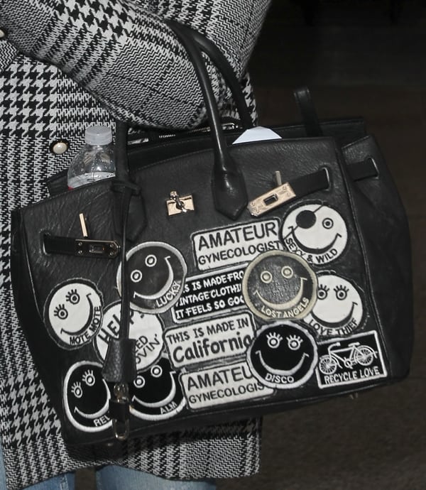 Kelly Osbourne’s black Hermès Birkin gets a rebellious makeover with playful stitched patches featuring smiley faces, quirky slogans, and tongue-in-cheek labels like “Amateur Gynecologist” and “This is Made in California”