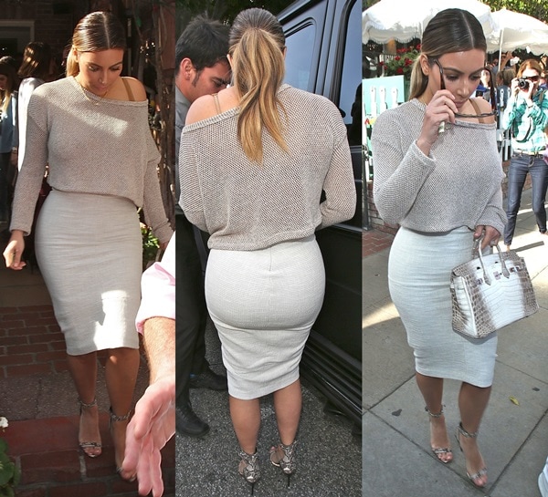 Kim Kardashian showcases her sleek monochromatic look—pairing a slouchy knit top with a white pencil skirt, Giuseppe Zanotti snake-print sandals, and a coveted Hermès Himalayan Birkin