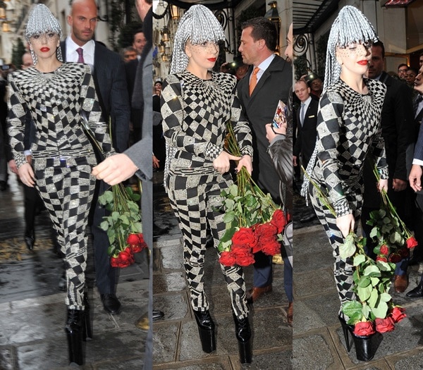 Carrying long-stemmed red roses, Lady Gaga greets fans outside her Paris hotel in the glittering black-and-silver jumpsuit and towering platform boots
