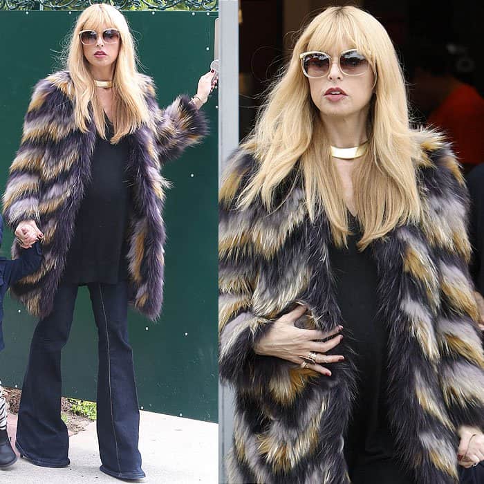 Rachel Zoe embraces her signature boho-glam aesthetic in flared maternity jeans, pairing the retro silhouette with a flowing black top, statement faux-fur coat, and oversized sunglasses in Los Angeles