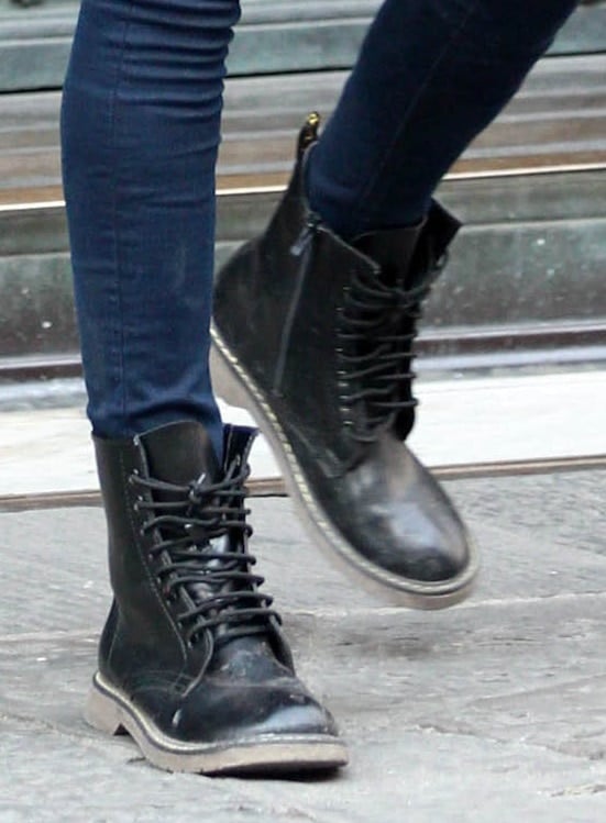 Cara Delevingne steps out in worn-in black combat boots featuring rugged stitching, a thick sole, and lace-up fronts—perfect for her edgy off-duty vibe
