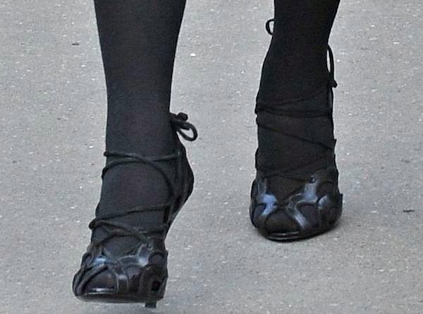 Kim Kardashian pairs her all-black ensemble with intricately laced black Tom Ford cutout heels, adding texture and edge to her winter look