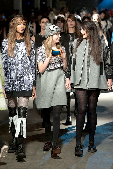 Cara Delevingne holding up her phone at the finale of the Giles Fall 2014 fashion show