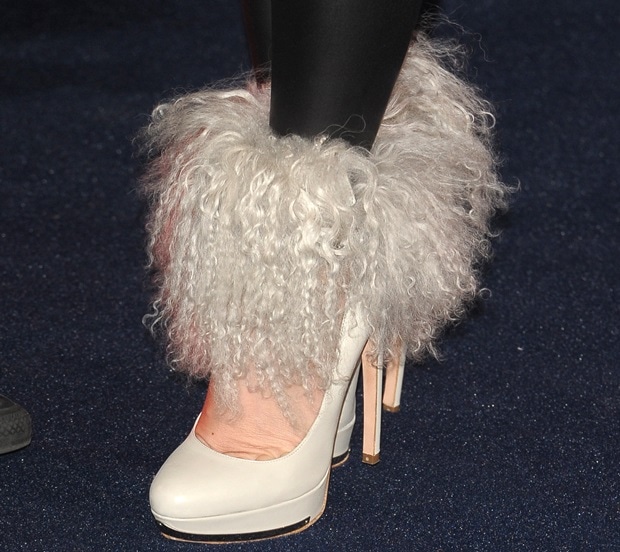 Alexander McQueen’s ivory platform pumps are wrapped in voluminous shearling cuffs, the sculptural height and plush texture transforming a classic silhouette into a statement piece