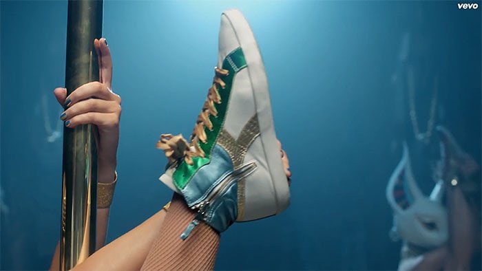A close-up of Katy Perry’s green, gold, and blue Diadora high-top sneakers