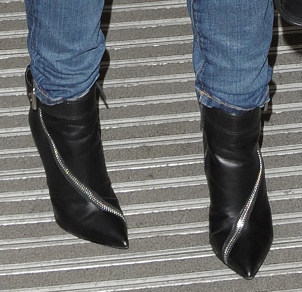 Kylie Minogue steps out in sleek Giuseppe Zanotti asymmetrical zip booties, crafted in black leather with bold diagonal zippers and silver buckle accents—adding an edgy twist to her casual denim look