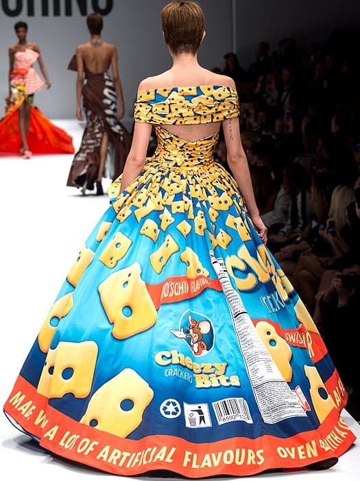 This full-length rear view of a Moschino Fall 2014 runway look displays a voluminous, off-the-shoulder ball gown