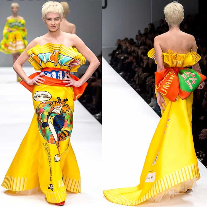 Moschino Fall 2014 showcases an eye-catching, strapless yellow gown inspired by Frosted Flakes packaging, featuring a ruffled bodice, a wide orange belt, and a voluminous skirt with a train