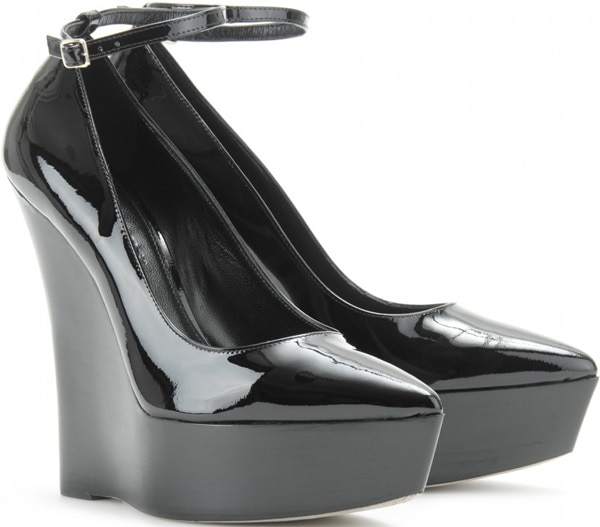 Burberry Prorsum’s “Chatsworth” platform wedges feature glossy black patent leather, sharply pointed toes, slim ankle straps, and sculptural curved platforms that create a dramatic, elongated silhouette