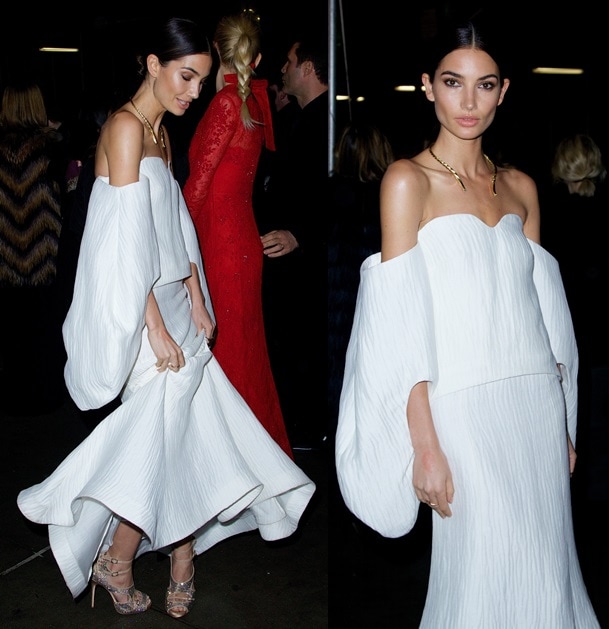 Lily Aldridge completes her elegant look with a sculptural gold collar necklace and crystal-embellished Tabitha Simmons “Bailey” sandals, adding sparkle to her white off-shoulder Rosie Assoulin gown at the 2014 amfAR New York Gala