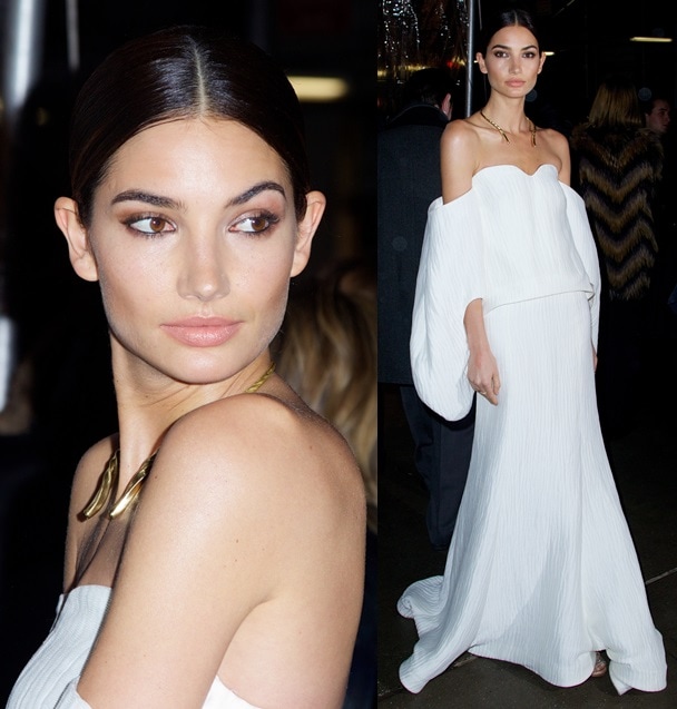 Lily Aldridge wears her hair in a sleek center-parted low bun and stuns in a white off-shoulder Rosie Assoulin gown paired with Tabitha Simmons’ nude crystallized “Bailey” sandals at the 2014 amfAR New York Gala