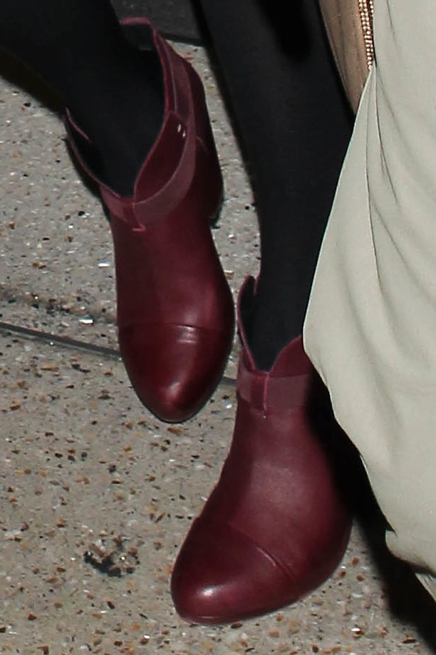 A detailed view of Taylor Swift's Rag Bone "Harrow" ankle boots, showcasing the distinctive "Port" red hue and notched topline