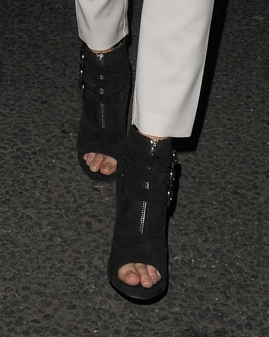 Cara Delevingne's black open-toed booties feature bold zipper details and multiple buckle accents