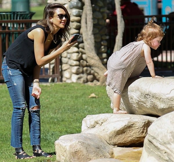 Jessica Alba enjoys a day at the park with her daughter in Los Angeles, wearing trendy destroyed jeans