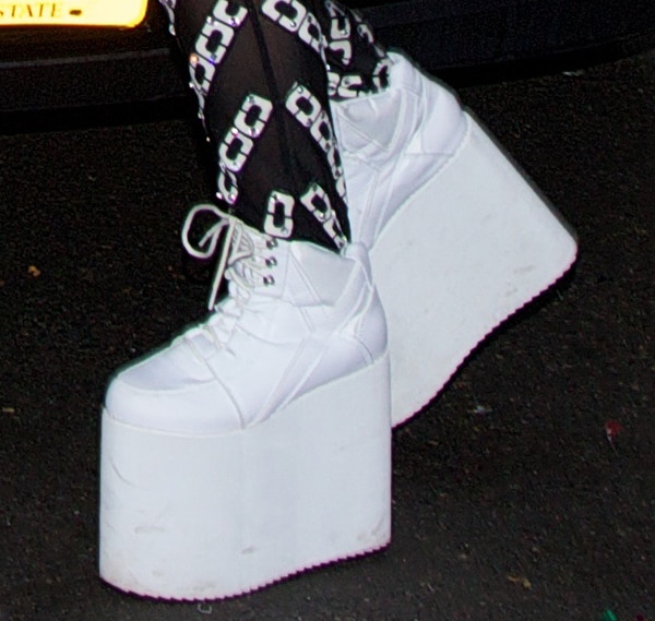 Lady Gaga wearing white lace-up sneakers with towering platforms