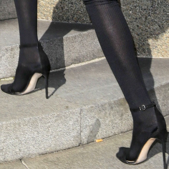 Rihanna styled her sleek black Manolo Blahnik "Chaos" sandals with ribbed black tights, creating a streamlined, elongating effect that balanced sophistication with an edgy touch