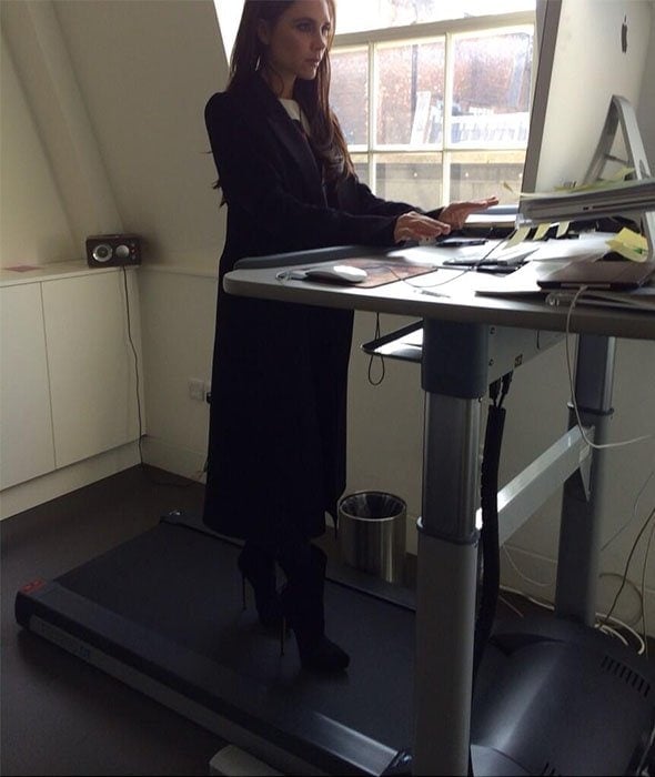 Victoria Beckham trying out a treadmill desk while wearing high-heeled booties in a snap she shared on Twitter on March 12, 2014