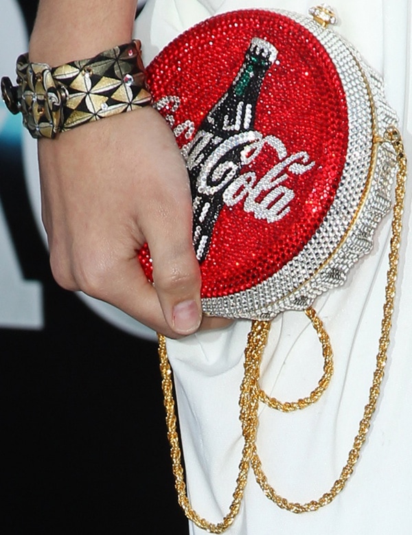 Chelsea Gilligan adds playful sparkle to her look with a Coca-Cola-themed crystal-embellished clutch and gold chain strap