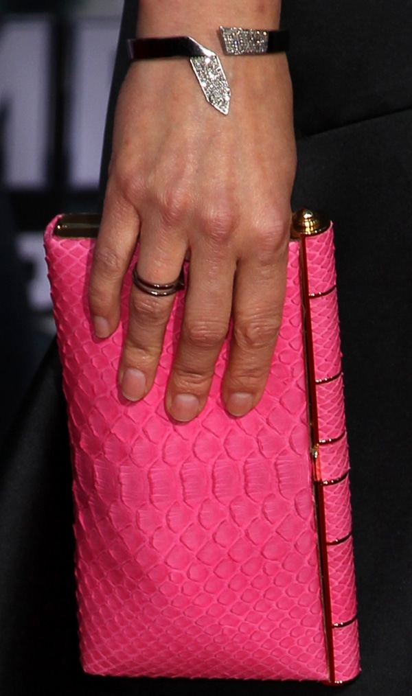 Cobie Smulders's vibrant hot pink clutch, with its distinctive texture, provides a bold and elegant accent to her minimalist ensemble