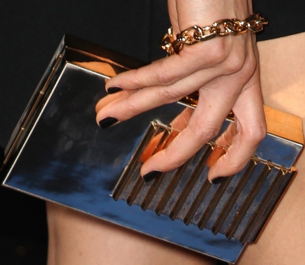Maggie Q completed her bold red carpet look with a gold clutch, matching chain bracelet, and dark manicure