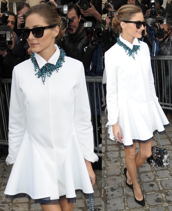 Olivia Palermo attends the Christian Dior Fall 2014 presentation in Paris, pairing a crisp white shirtdress with classic black pointy pumps and bold accessories for a chic, modern look