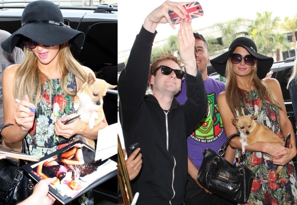 Paris Hilton carrying her Chihuahua while signing autographs and posing for photographs with her fans at LAX in Los Angeles
