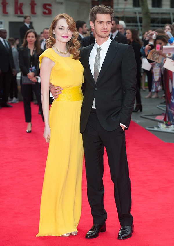 Emma Stone brightens the red carpet in a vibrant yellow Atelier Versace gown, styled with Christian Louboutin ‘Viveka’ sandals that subtly peek through the hem, while Andrew Garfield keeps it classic in a sharp black suit at The Amazing Spider-Man 2 London premiere