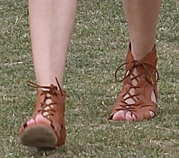 The tan leather gladiator sandals show off whipstitched seams and scalloped cutouts, bringing texture and edge to her Coachella ensemble
