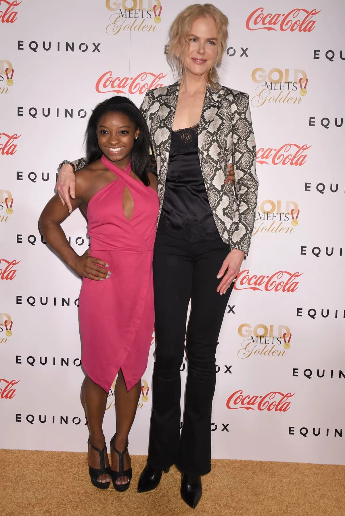 Simone Biles, standing at 4'8" (142.2 cm), contrasts sharply with the statuesque Nicole Kidman, whose towering frame is further emphasized by sleek black pointed-toe heels and sharply tailored separates