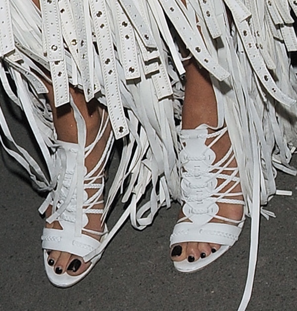 Rita’s Cavalli sandals stand out beneath the heavy fringe, highlighting the design’s woven straps and open-toe silhouette