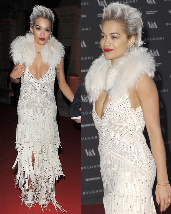 Rita Ora showcases the intricate studwork, plunging neckline, and plush fur collar of her Roberto Cavalli gown on the red carpet
