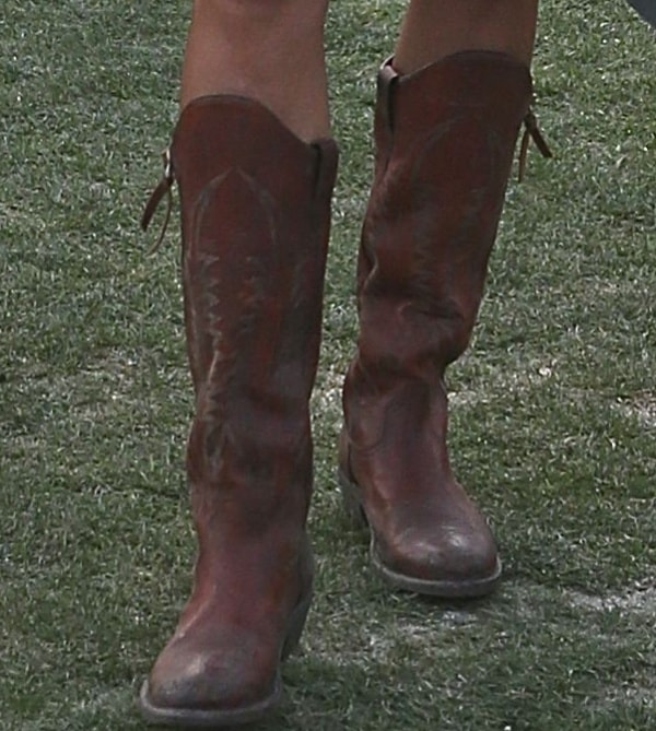 Alessandra Ambrosio completes her desert-ready look with distressed dark brown cowboy boots, adding rugged contrast to her feminine bohemian ensemble