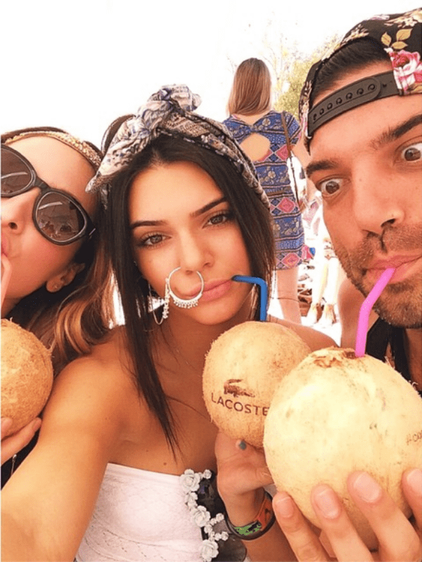 Kendall Jenner enjoys coconut drinks with friends at the Lacoste pool party, rocking her signature nose ring and effortless desert-glam style