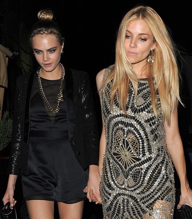 Standing 5ft 5in (165.1 cm), Sienna Miller dazzled in a silver beaded mini dress from Kate Moss’s Topshop collection, while the 5ft 7¼in (170.8 cm) Cara Delevingne opted for a sleek black satin playsuit with a sequined jacquard blazer, also from the Kate Moss Topshop line