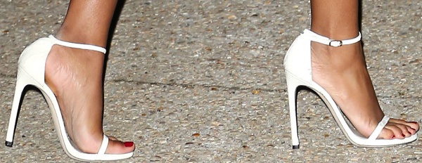 Solange Knowles boosts her height in customized white Stuart Weitzman Nudist sandals, letting the sleek ankle-strap design and contrasting red pedicure make a bold statement