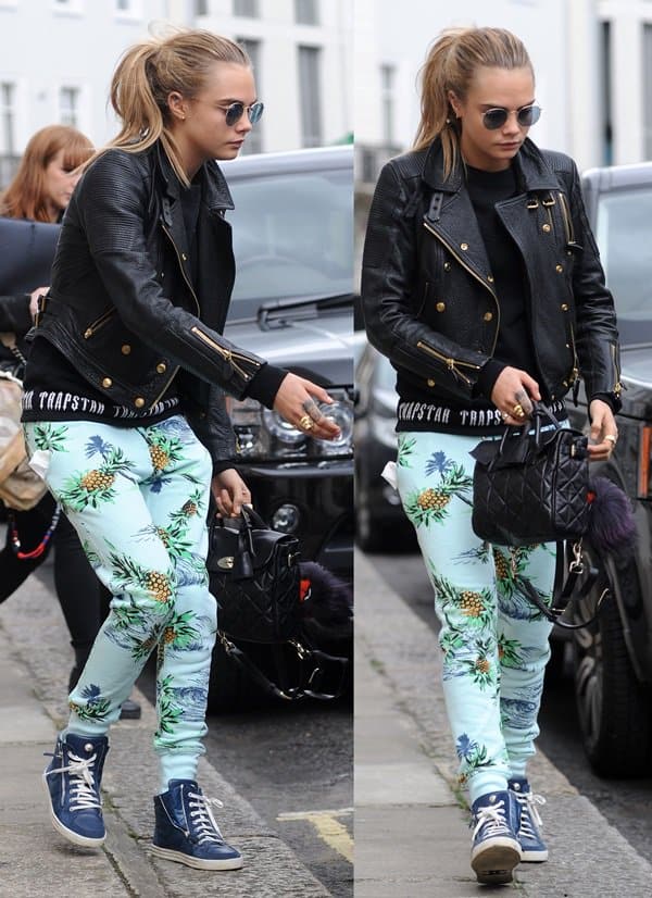 Cara Delevingne Wearing Low Waist Sweat Pants Cara Delevingne showcases a stylish ensemble with Zoe Karssen tropical print sweatpants, a Burberry biker jacket, a Mulberry bag, and Chanel high-top sneakers while out in London