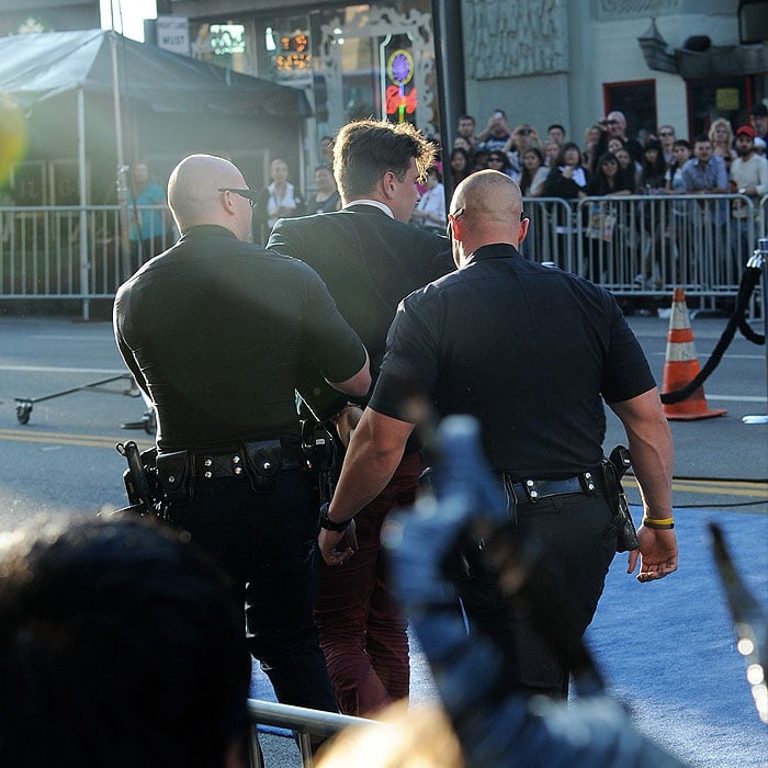 Police arresting and leading away Vitalii Sediuk, the man who jumped the barriers and tried to make contact with Brad Pitt's face as the actor walked down the red carpet