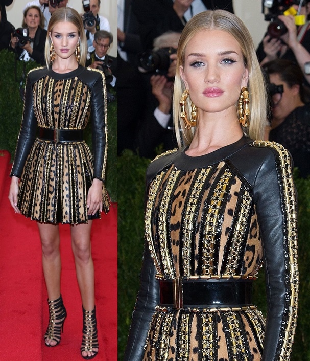 Rosie Huntington-Whiteley turned heads in a custom Balmain mini dress featuring bold leopard print, gold embellishments, and structured leather accents, styled with gladiator heels and oversized statement earrings