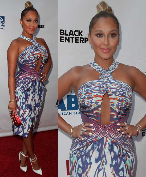 Adrienne Bailon turned heads in a vividly patterned Dion Lee halter dress featuring a daring front cutout and crisscross waist detail, perfectly paired with white Tom Ford padlock pumps that added sleek polish to her bold, body-conscious look